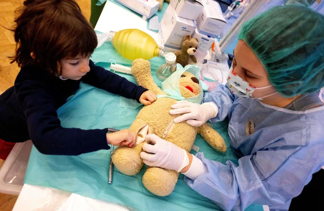 Zdravnica Tessa in štiriletni Dian operirata plišastega medvedka med dogodkom Bolnišnica za plišaste medvedke, ki ga je organiziralo zdravniško združenje na Dunaju. Približno 60 zdravnikov je sodelovalo v akciji, namenjeni odpravljanju strahu otrok pred obiskom zdravnika ali hospitalizacijo. Foto: Joe Klamar/Afp