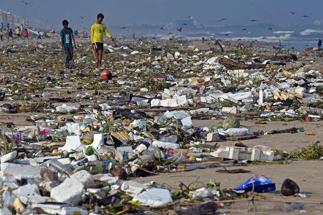 Dečki se sprehajajo na plaži v Chennaiju po močnem deževju. Po ulicah južnega indijskega mesta Chenna. Foto: Afp