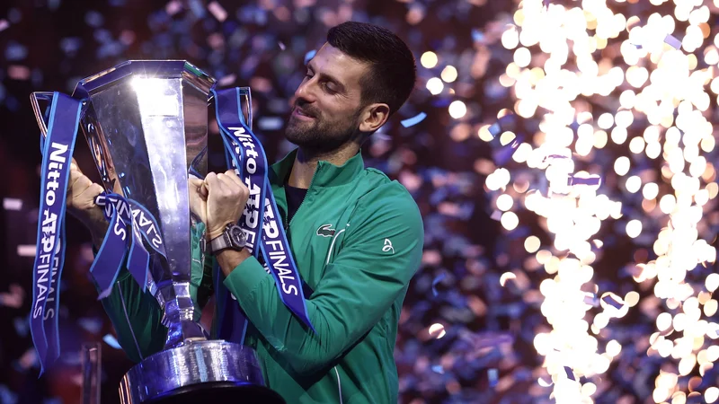 Novak Đoković s pokalom za zmagovalca zaključnega turnirja najboljše osmerice v Torinu. FOTOO: Guglielmo Mangiapane/Reuters