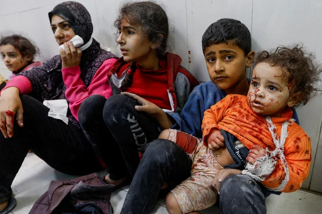 Ranjeni palestinski otroci sedijo na tleh v bolnišnici Nasser v mestu Khan Younis na jugu Gaze po izraelskih bombnih napadih, ki so posledica konflikta med Izraelom in palestinsko islamistično skupino Hamas. Foto: Ibraheem Abu Mustafa/Reuters