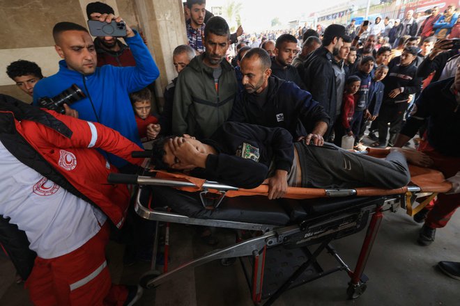 Prenos ranjenega Palestinca v bolnišnici Naser v mestu Han Junis na jugu Gaze. FOTO: Mahmud Hams/AFP