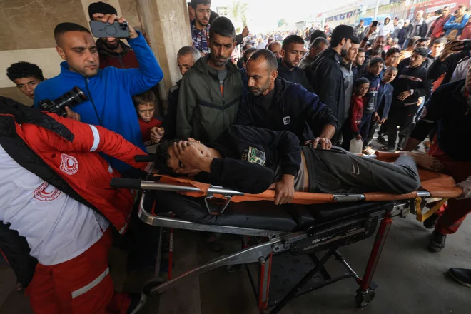 Prenos ranjenega Palestinca v bolnišnici Naser v mestu Han Junis na jugu Gaze. FOTO: Mahmud Hams/AFP