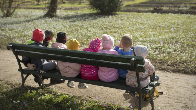 Fotografija: Skupina otrok na klopci v Botaničnem vrtu februarja leta 2021. Fotografija je simbolična. FOTO: Jure Eržen/Delo