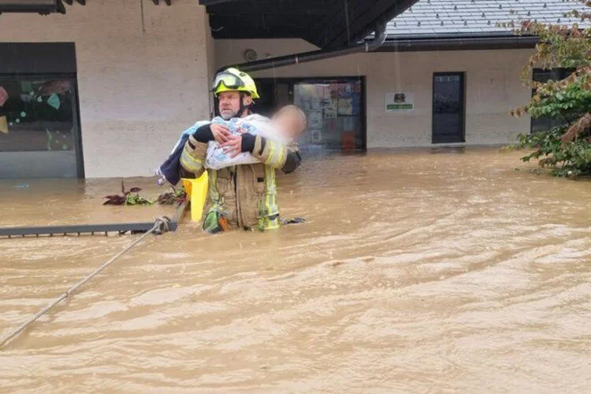 Gasilec Sandi Zajc rešuje otroke. Foto Kaja Fikfak