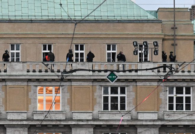 Oboroženi policisti na balkonu univerze, v kateri je 24-letnik umoril 14 ljudi. FOTO: Michal Cizek/AFP