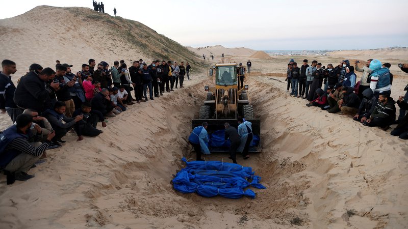 Fotografija: Palestinci pri pokopu svojih bližnjih. FOTO: Ibrahim Abu Mustafa/Reuters