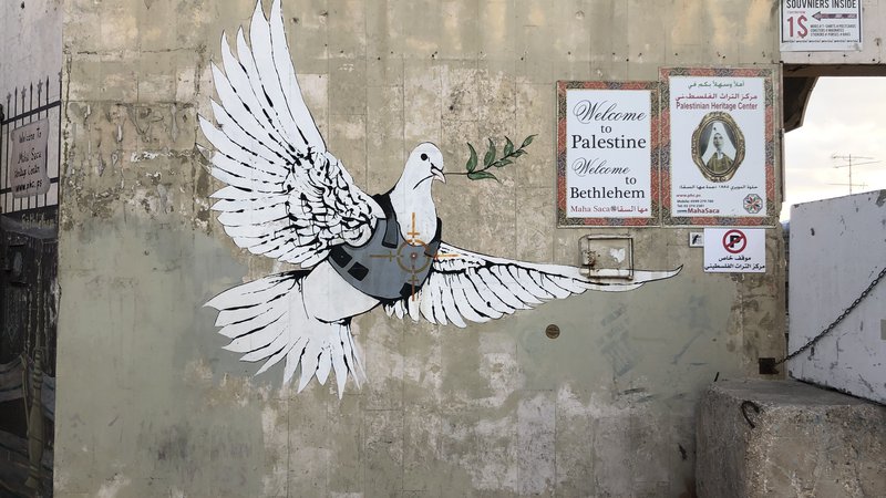 Fotografija: Banksyjev grafit v Betlehemu je nastal leta 2003. FOTO: Wikipedia, Creative Commons