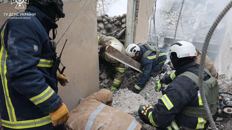 Fotografija: Ukrajinski gasilci izpod ruševin rešujejo morebitne preživele. FOTO: Handout Afp