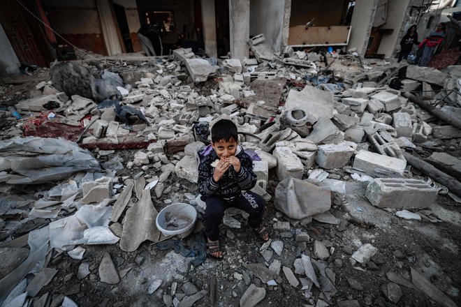 Deček v Gazi sedi na ruševinah uničenih poslopij. FOTO: Afp