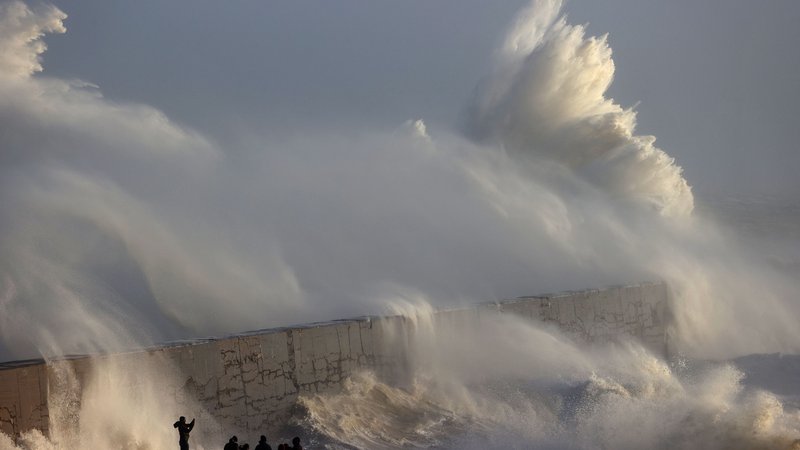 Fotografija: Oseba fotografira valove, ki se lomijo ob valobran v Newhavnu, saj je nevihta Henk prinesla močan veter in obilno deževje v večji del južne Anglije. Foto: Adrian Dennis/Afp