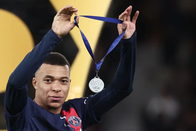 Kylian Mbappe z medaljo za zmagovalca superpokala. FOTO: Franck Fife/AFP