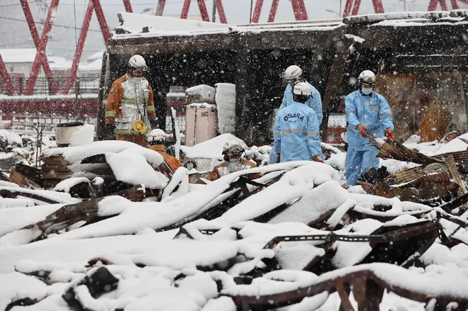 Gasilci iščejo morebitne preživele pod ruševinami. FOTO: Str. AFP