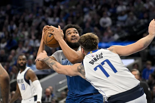 Luka Dončić se je odločno postavil po robu precej višjemu Karl-Anthonyju Townsu (z žogo). FOTO: Jerome Miron/USA Today Sports