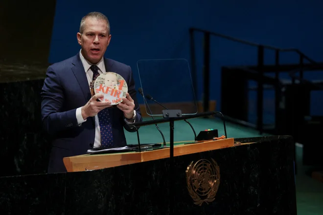 Izraelski veleposlanik Gilad Erdan s sliko ugrabljenega dečka, ki je v Hamasovem ujetništvu dočakal prvi rojstni dan. FOTO: Shannon Stapleton/Reuters