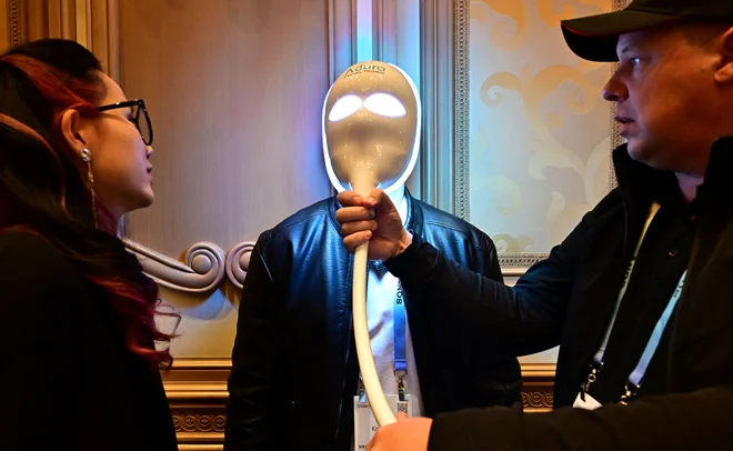 Moški preizkuša masko za obraz Aduro Facial Tronic podjetja Red Lite Therapy Collective na sejmu zabavne elektronike (CES) v Las Vegasu. Maska za obraz Aduro Facial Tronic ponuja sedem barv za zdravljenje v rdeči, zeleni, modri, rumeni, oranžni, cian, vijolični in infrardeči, ki pomagajo pri vnetjih, preprečevanju staranja, aknah, odstranjevanju madežev, mehkejši koži, uravnoteženih tonih kože in pomlajevanju celic. Foto: Frederic J. Brown/Afp