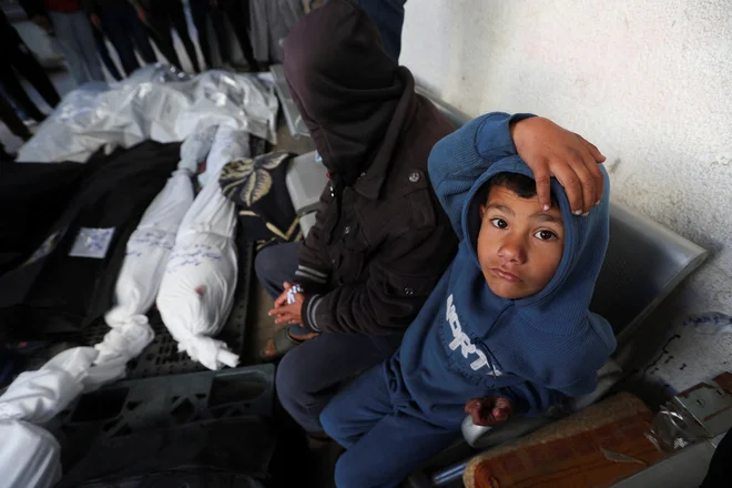 Palestinci ob truplih ubitih v izraelskih napadih. FOTO: Ibraheem Abu Mustafa/Reuters