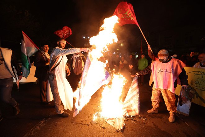 Iranski protestniki med zažiganjem ameriške in izraelske zastave. Foto Atta Kenare/Afp