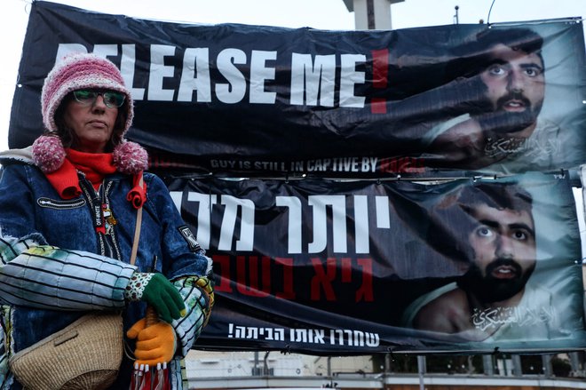 Množica v Tel Avivu je nosila velik transparent z napisom: »In svet še vedno molči.« Udeleženci so vzklikali, da je treba talce »zdaj, zdaj, zdaj« izpustiti. FOTO: Gil Cohen-magen/AFP