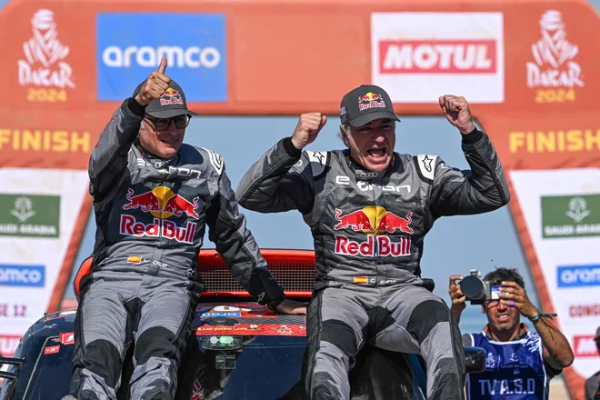 Carlos Sainz starejši (desno) s sovoznikom Lucasom Cruzofom po letošnjem, podvigu v Dakarju. FOTO: Patrick Hertzog/AFP