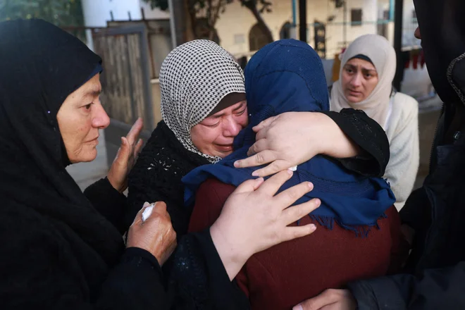 Palestinke objokujejo mrtve, ki so jih pokopali v skupnem grobišču. FOTO: Afp