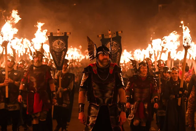 Člani skupine »Jarl Squad« paradirajo po ulicah mesta Lerwick na Šetlandskih otokih med festivalom Up Helly Aa. Up Helly Aa praznuje vpliv skandinavskih Vikingov na Shetlandskih otokih, vrhunec pa doseže z do 1000 moškimi v kostumih, ki zvečer v vikinško ladjo vržejo goreče bakle in jo zažgejo. Foto: Andy Buchanan/Afp