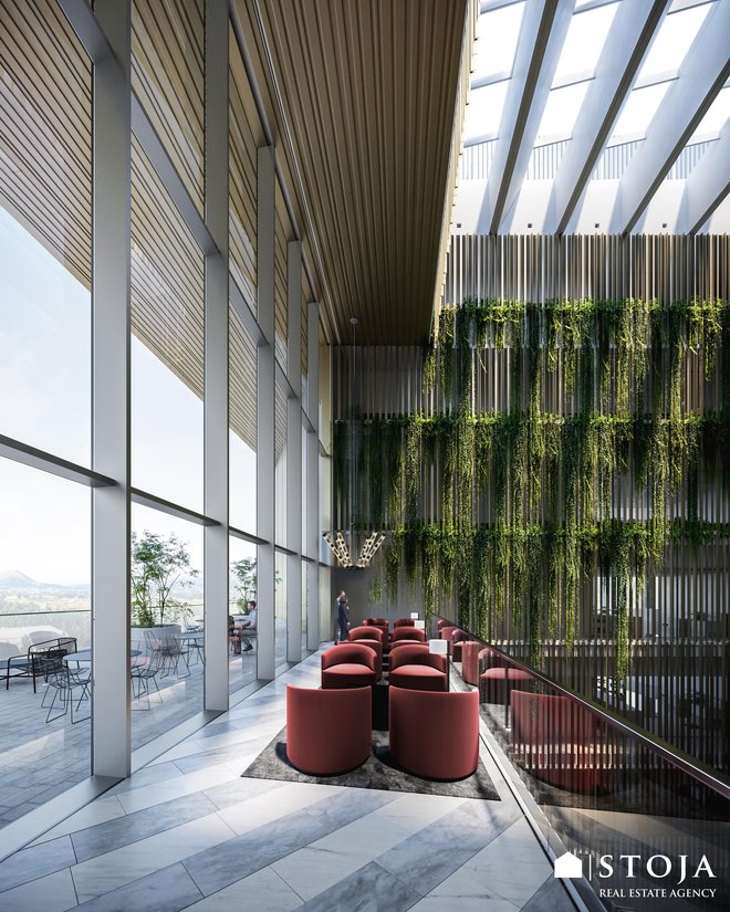 Vzdolž celotne notranjosti stavbe se razprostira veliki atrij z zelenjem, ki omogoča dotok naravne svetlobe v vse prostore. FOTO: BAX studio