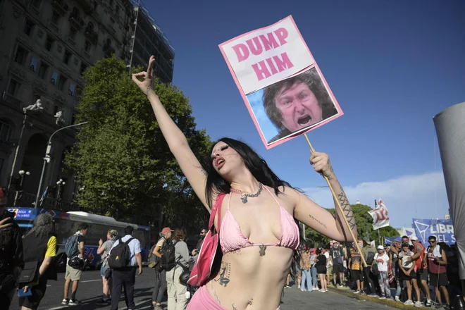 V Buenos Airesu spolna je delavka pred kongresom držala transparent s podobo novega argentinskega predsednika Javierja Mileja, medtem ko so zakonodajalci razpravljal o vladnem predlogu zakona o gospodarskih reformah. Argentinski kongres je po napetem dnevu, ko so bili med incidenti med protestniki in varnostnimi silami pred parlamentom aretirani štirje ljudje, nadaljeval razpravo o spornem paketu ultra-liberalnih reform predsednika Javierja Mileja. Foto: Juan Mabromata/Afp