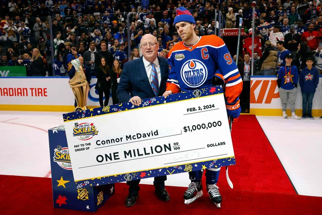 Za nagrado je Connor Mcdavid prejel ček za milijon dolarjev. FOTO: Bruce Bennett/AFP