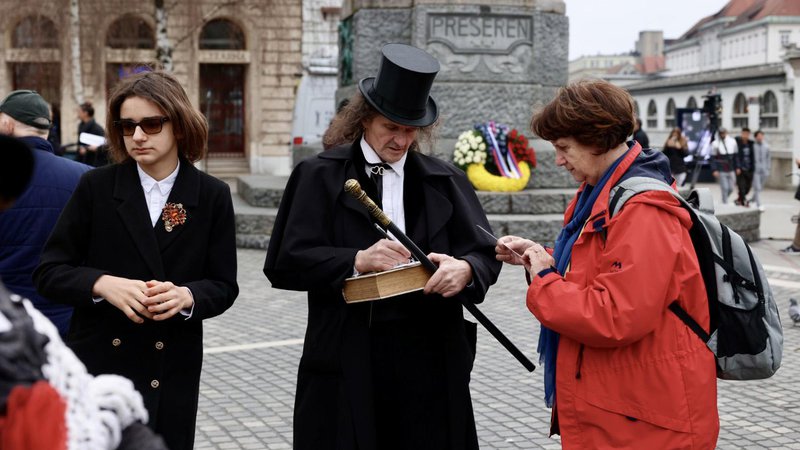 Fotografija: Ob tradicionalnem branju poezije pred spomenikom Franceta Prešerna se je zbrala množica ljudi. FOTO: Črt Piksi