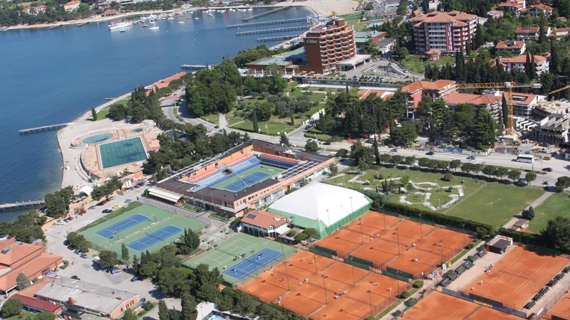 Pogled na Tenis center Portorož: sedem peščenih igrišč v desnem spodnjem kotu bi v celoti preuredili za druge športe. Dve betonski (modri) na levi bi postali večnamenski. Balon nad dvema igriščema pa bi postavili samo pozimi. Foto Boris Šuligoj