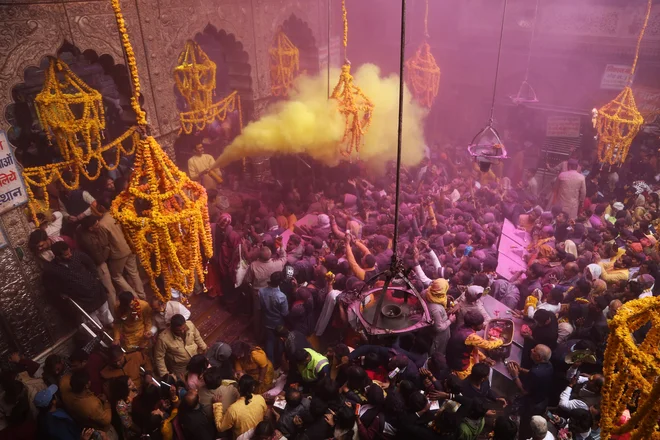 Duhovnik meče barvni prah na hindujske vernike v templju Sri Bankey Bihari v Vrindavanu med praznovanjem festivala Basant Panchami, ki zaznamuje priprave na prihod pomladi. Foto: Afp