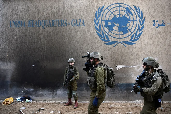 Izraelski vojaki ob sedežu agencije Združenih narodov
za palestinske begunce UNRWA v Gazi FOTO: Dylan Martinez/Reuters