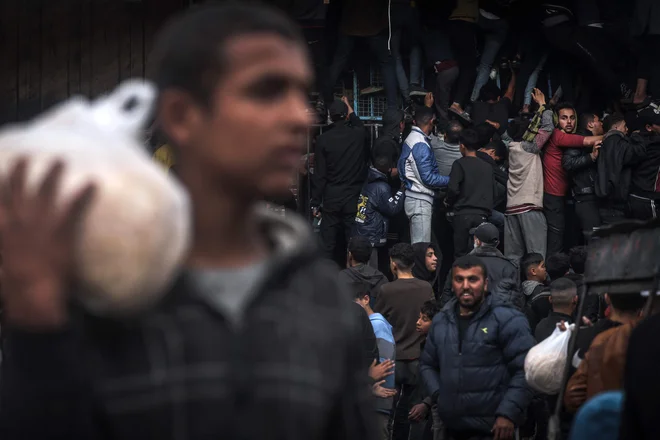 Palestinci se gnetejo pred pekarno v Rafahu, da bi kupili kruh. Foto: Mohammed Abed/Afp