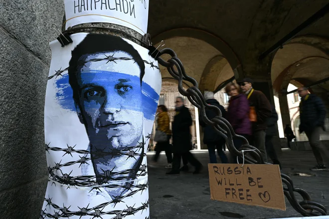 People walk past a poster of late Russian opposition leader Alexei Navalny, who died in a Russian Arctic prison, on February 24, 2024 in the center of Milan. A placard reads 'Russia will be free'. (Photo by GABRIEL BOUYS/AFP) Foto Gabriel Bouys Afp