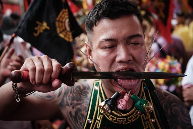 Moški, ki naj bi bil v transu, si reže jezikv templju v Karawangu na zahodu Jave med festivalom Cap Go Meh, ki zaznamuje zadnji dan lunarnega novega leta zmaja, ko je polna luna najsvetlejša,. Foto: Yasuyoshi Chiba/Afp