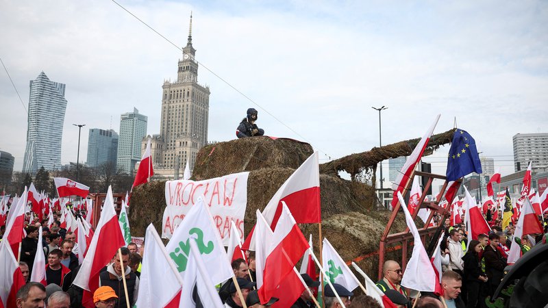 Fotografija: Protestniki v Varšavi s tankom, izdelanim iz senenih bal. FOTO: Kacper Pempel/Reuters