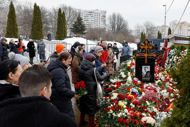 Kljub grožnji aretacij se je včerajšnjega pogreba udeležilo več tisoč ljudi, vključno s tujimi diplomati, ljudje tudi danes prihajajo na grob. FOTO: Reuters