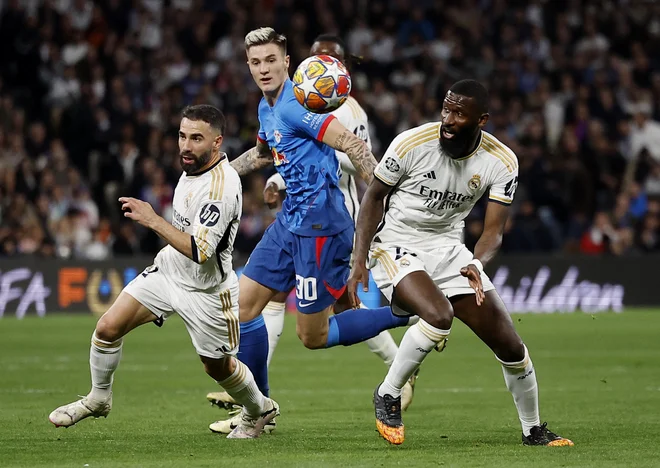 Benjamin Šeško je bil pogosto obkrožen z Realovimi branilci, takole sta ga ustavila Antonio Rüdiger in Dani Carvajal. REUTERS/Juan Medina FOTO: Juan Medina/Reuters