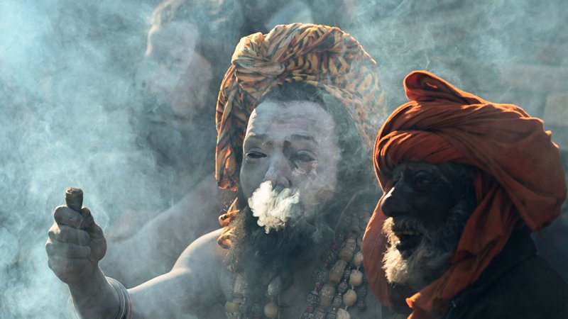Fotografija: Hindujski sveti možje kadijo s tradicionalnimi glinenimi pipami na predvečer Maha Šivaratrija, letnega festivala, posvečenega hindujskemu bogu Šivi, v templju Pashupatinath v Katmanduju. Foto: Prakash Mathema/Afp