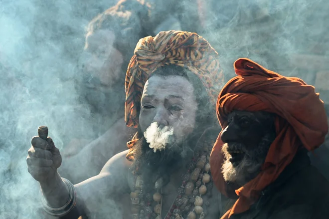 Hindujski sveti možje kadijo s tradicionalnimi glinenimi pipami na predvečer Maha Šivaratrija, letnega festivala, posvečenega hindujskemu bogu Šivi, v templju Pashupatinath v Katmanduju. Foto: Prakash Mathema/Afp