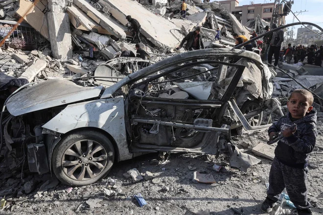 Palestinski deček med ruševinami, ki so jih povzročili izraeslki napadi. FOTO: Said Khatib/Afp