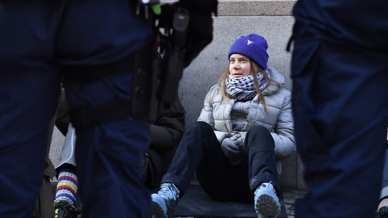 Fotografija: Danes zjutraj sta dva policista »na silo« dvignila podnebno aktivistko Greto Thunberg in jo odnesla stran od vrat švedskega parlamenta. FOTO: Samuel Steen/AFP