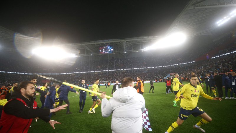 Fotografija: Po zadnjem sodnikovem žvižgu se je igrišče spremenilo v ring, nogometaše Fenerbahčeja so napadli navijači Trabzonsporja.  FOTO: Handout/AFP