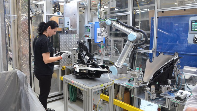 Fotografija: Proizvodnja žarometa, pri kateri operater sodeluje s tako imenovanim kolaborativnim robotom. FOTO: Gašper Boncelj