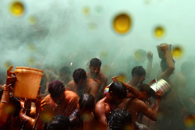 Hindujski verniki sodelujejo v igri huranga, ki jo moški in ženske igrajo dan po Holiju, v templju Daujii v bližini mesta Mathura na severu Indije. Foto: Sharafat Ali/Reuters