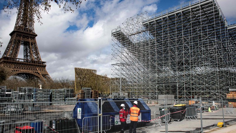 Fotografija: Središče Pariza je pred olimpijskimi igrami kot veliko zastraženo gradbišče. Pri Eifflovem stolpu med drugim urejajo igrišče za odbojko na mivki. FOTO: Guillaume Baptiste/AFP