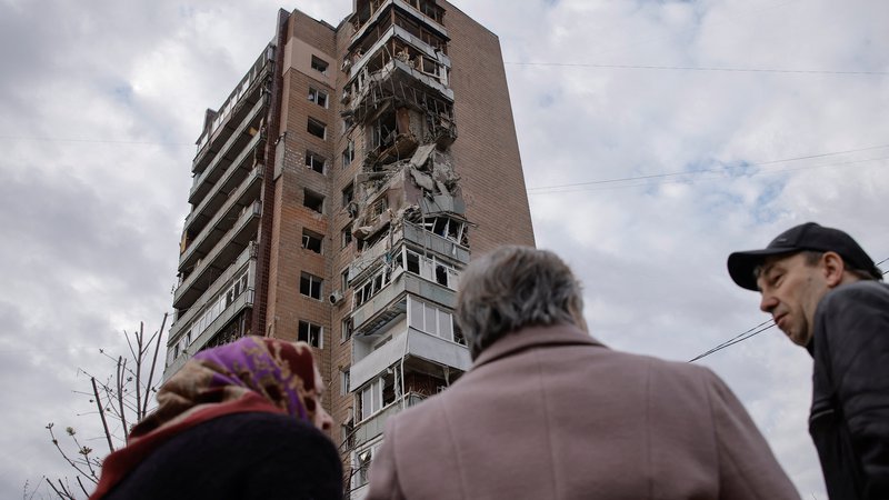 Fotografija: Prebivalci Harkova red eno od poškodovanih stavb. FOTO: Stringer Reuters