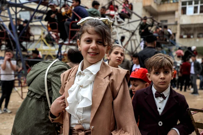 Otroci, oblečeni v nova oblačila čakajo na veselo vožnjo v mestu Ariha v sirski uporniški severozahodni provinci Idlib, na prvi dan muslimanskega praznika Eid al-Fitr, ki se zaključi s svetim mesecem ramadan. Foto: Aaref Watad/Afp