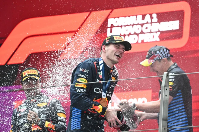 Max Verstappen je užival v šampanjski prhi po dirki v Šanghaju. FOTO: Greg Baker/AFP