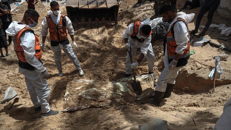 Fotografija: V zadnjih petih dneh so pripadniki palestinske civilne zaščite, ki jim pomagajo forenziki, iz množičnega grobišča odkopali 324 trupel, ki so bila pred bolnišnico Naser prekrita z zemljo, ruševinami in smetmi. FOTO: AFP